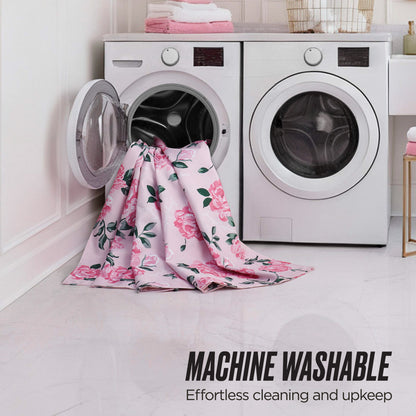 The Shower Curtain and Hooks Set in pink floral fabric hangs from a front-loading washing machine in a modern laundry room with a matching dryer. Text reads: MACHINE WASHABLE for easy cleaning and effortless bathroom decor upkeep.
