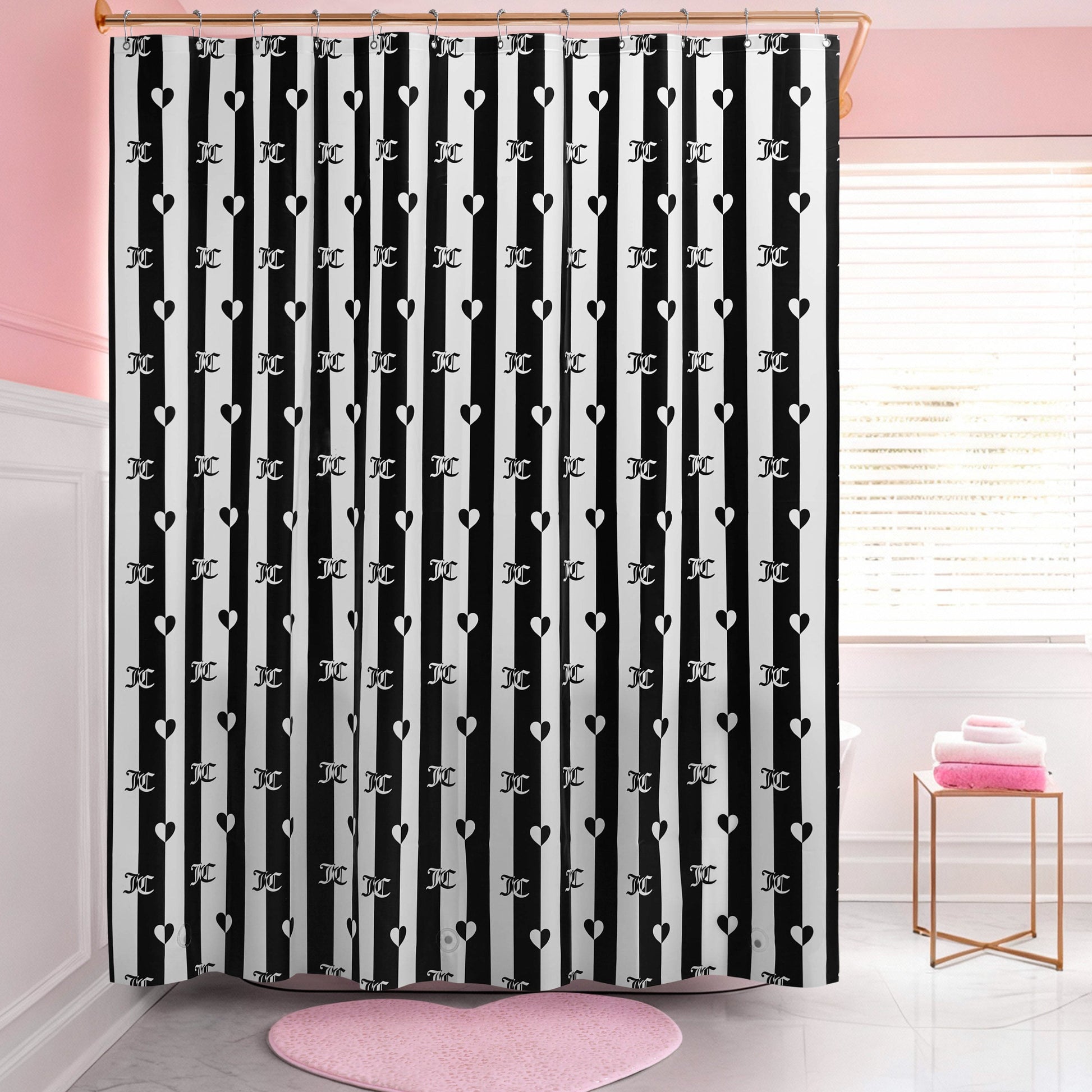 A bathroom with a PEVA Shower Curtain Liner in black-and-white stripes featuring heart and letter J patterns, pink walls, a round pink rug, and folded pink towels on a white stool by the window.