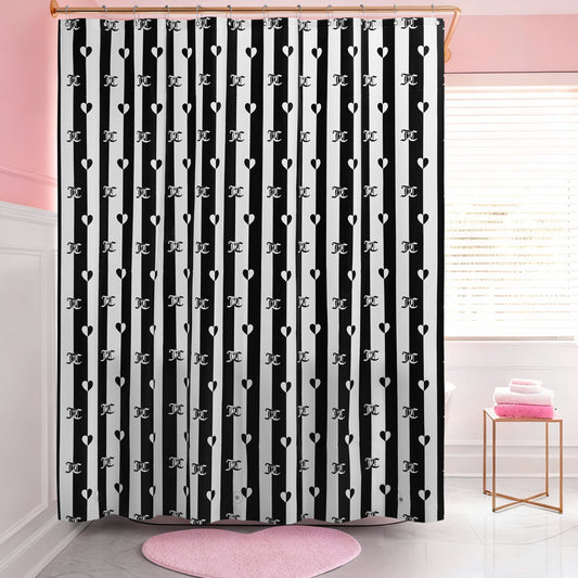 A bathroom with a PEVA Shower Curtain Liner in black-and-white stripes featuring heart and letter J patterns, pink walls, a round pink rug, and folded pink towels on a white stool by the window.
