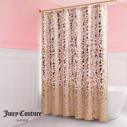 A pink and white bathroom features the Shower Curtain and Hooks Set in a gold and pink animal print, suspended from a curved rod. The Juicy Couture Home logo is displayed in the lower left corner, adding chic style to your decor.