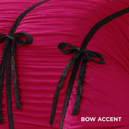 Close-up of the Amelie Bows Ruched Comforter Set in hot pink, featuring ruched fabric, two black satin and velvet bows, and black piping. “BOW ACCENT” appears in white text at the bottom right corner.