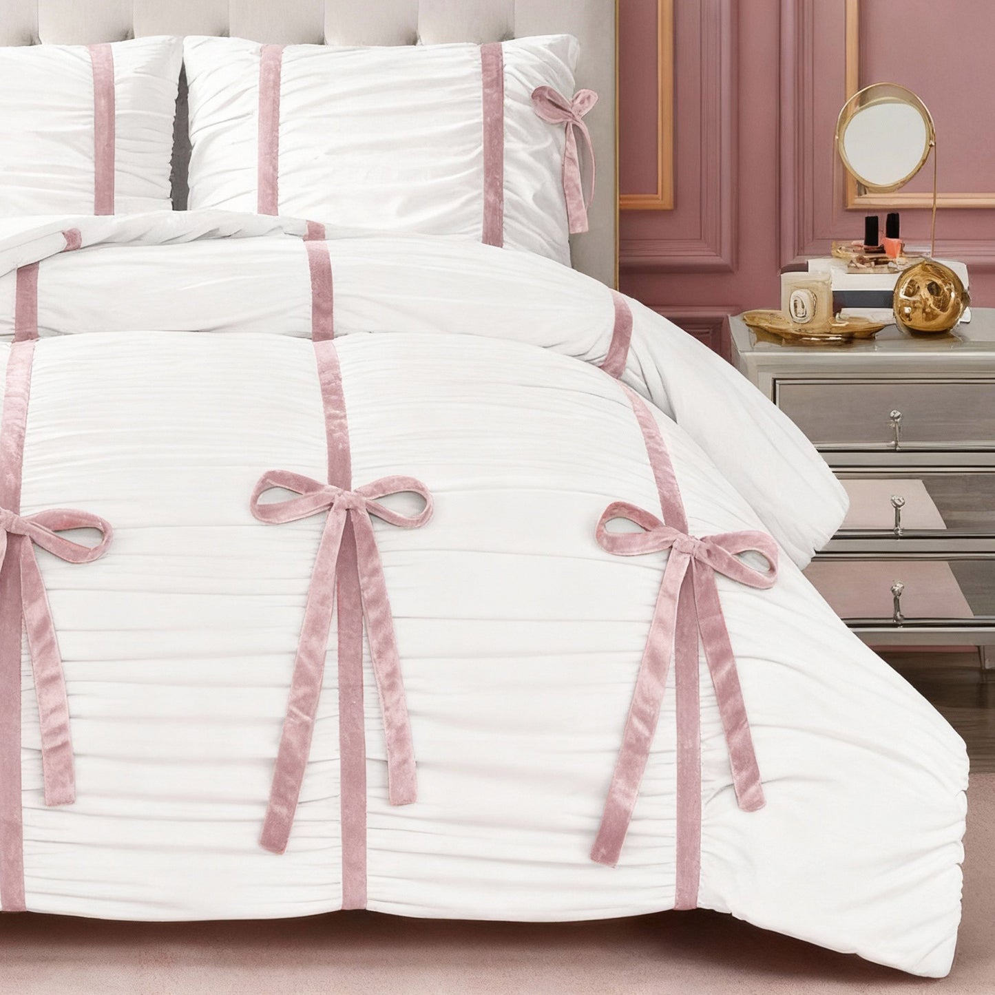 The Amelie Bows Ruched Comforter Set, featuring vertical pink velvet bows, is styled on the bed and pairs beautifully with a mirrored nightstand, round mirror, gold decor, and blush pink paneled walls.