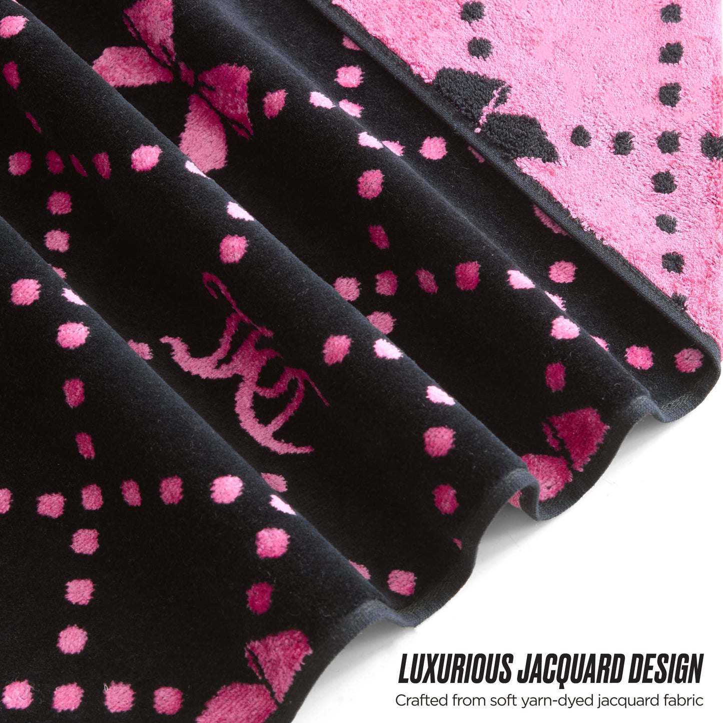 Close-up of a black and pink jacquard fabric with decorative patterns and dots. LUXURIOUS JACQUARD DESIGN—crafted from soft yarn-dyed jacquard for the stylish Printed Jacquard Bath Towel Set collection.