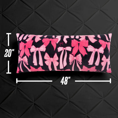 The Plush Body Pillow, featuring a pink bow pattern on black and measuring 20"x48", is shown against a black textured backdrop with measurement markers along the sides.