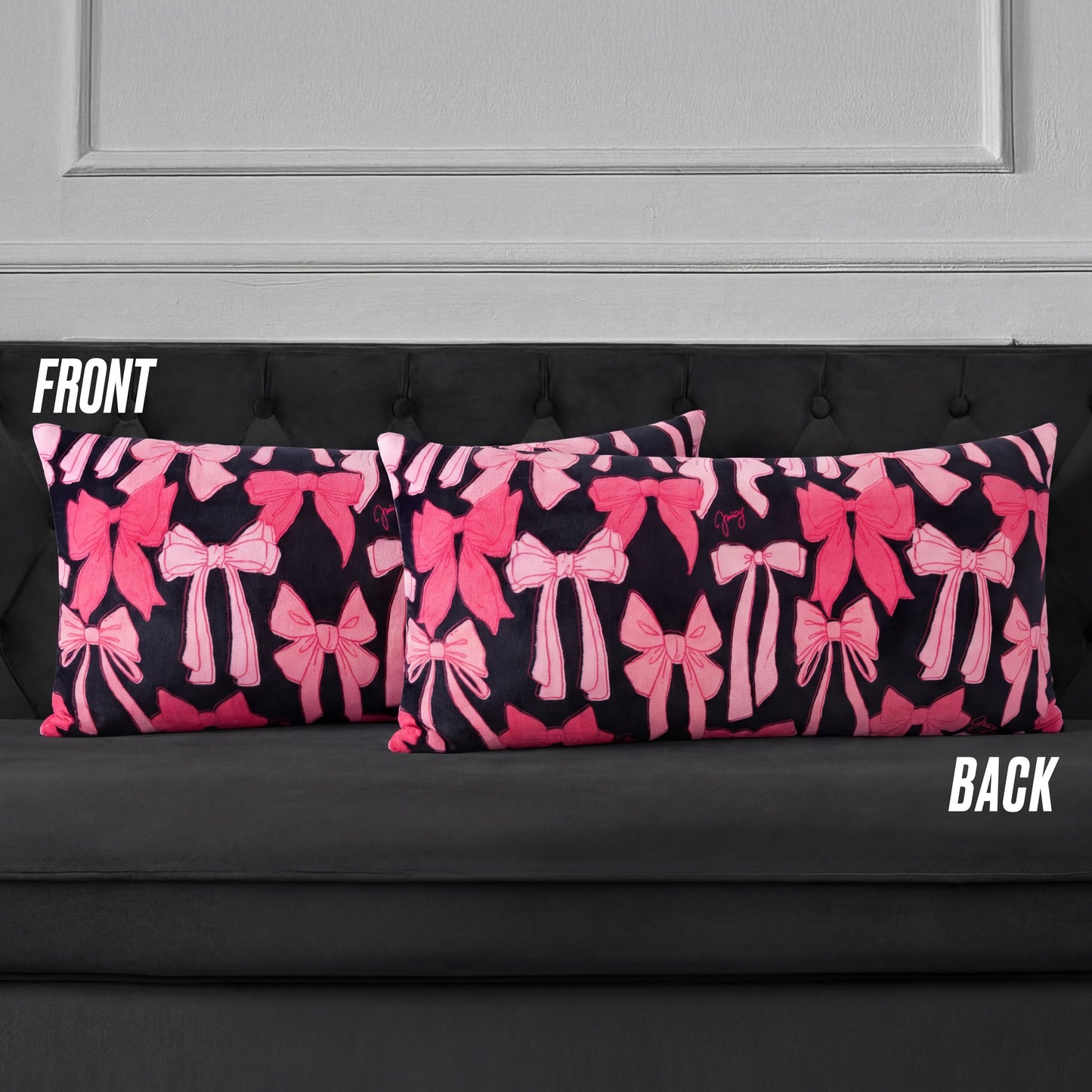 Two rectangular Plush Body Pillows with a pink bow pattern on a dark background are displayed on a black tufted sofa. Labels "FRONT" and "BACK" show both sides feature the same bow design.