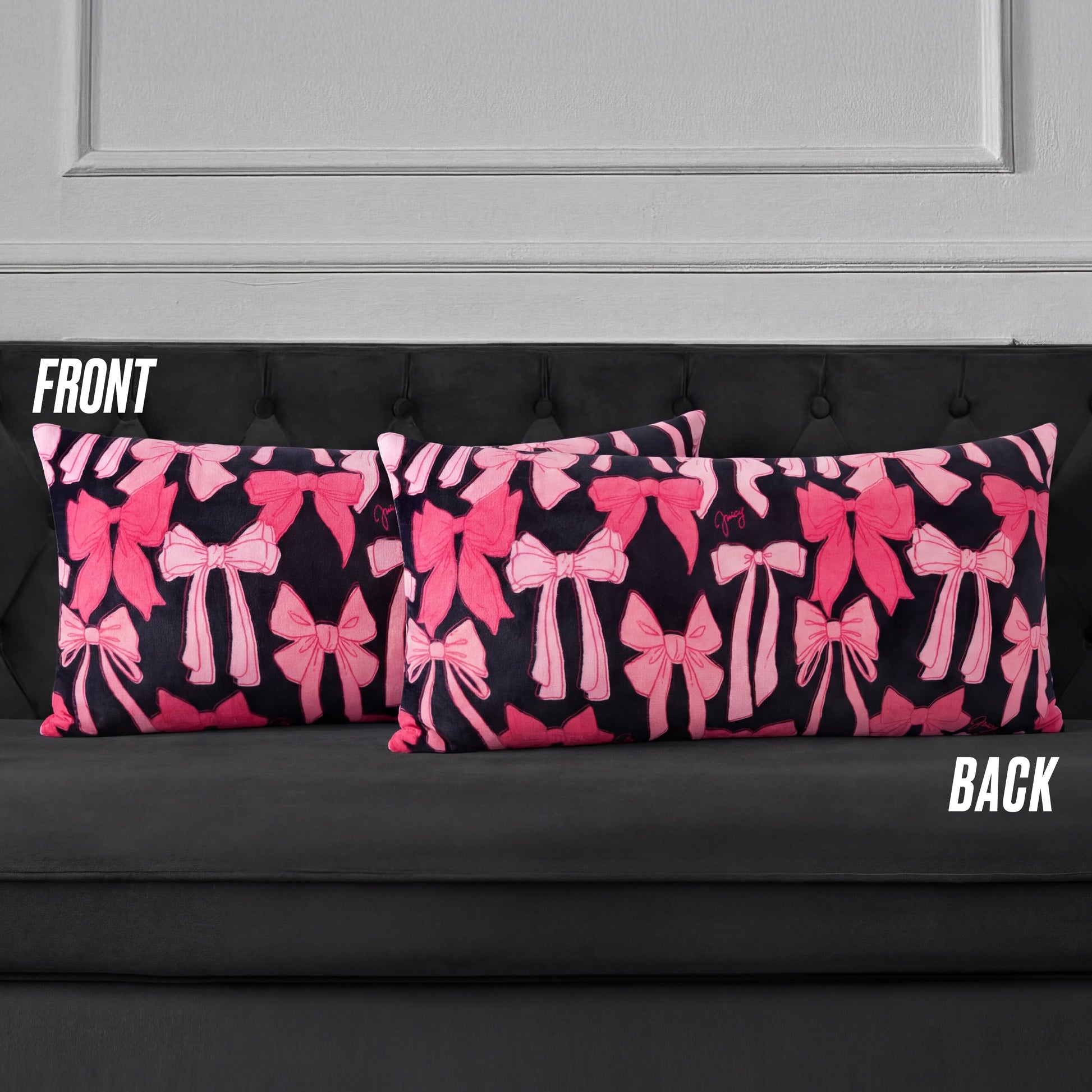 Two rectangular Plush Body Pillows with a pink bow pattern on a dark background are displayed on a black tufted sofa. Labels "FRONT" and "BACK" show both sides feature the same bow design.