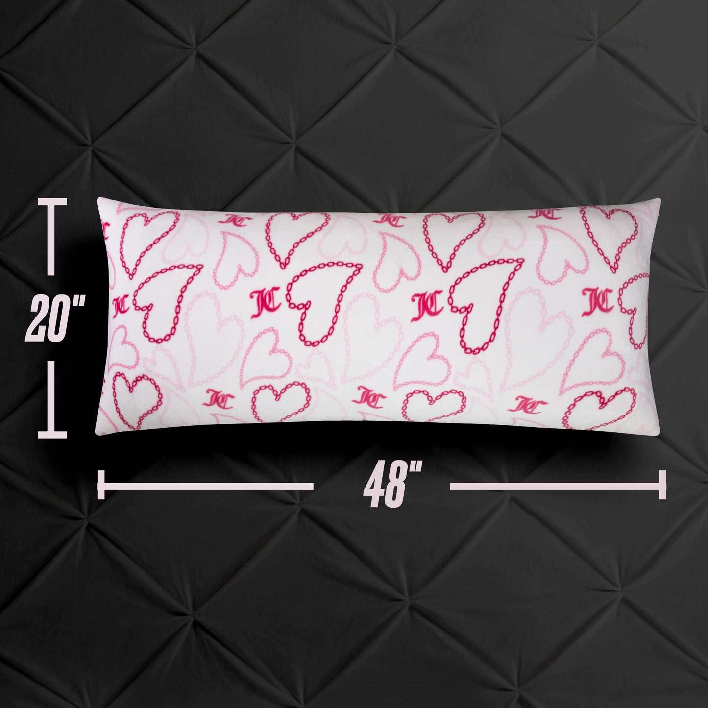 The Plush Body Pillow, measuring 20 x 48 inches, is rectangular and white with pink and red hearts plus MC initials, resting on a black textured surface. This oversized pillow brings a stylish accent to any space.