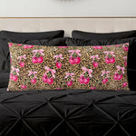 A Plush Body Pillow featuring a leopard print with bright pink cherries and pink bows, shown on black bedding and a cream-colored headboard.