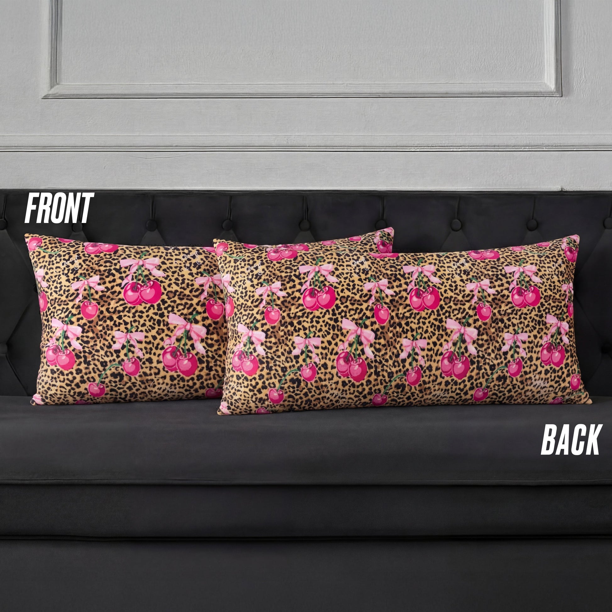 Two rectangular Plush Body Pillows on a black couch display a pink cherry and brown leopard print, reminiscent of Juicy Couture. Labels "FRONT" and "BACK" show both sides of the design.