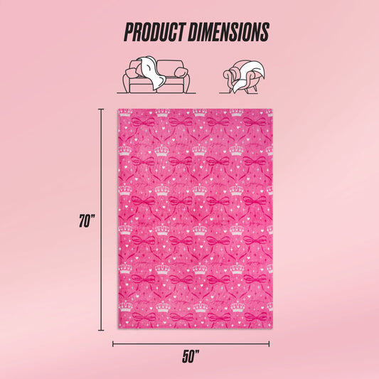 The Kids Plush Throw Blanket features crown and bow patterns, measures 70"x50", and is shown on a pink gradient background with product dimensions plus icons of a couch and a woman enjoying this ultra-soft blanket.