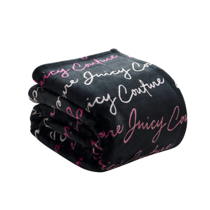 A folded black Plush Oversized Throw Blanket, ultra-soft and plush, featuring "Juicy Couture" repeatedly in white and pink cursive lettering.
