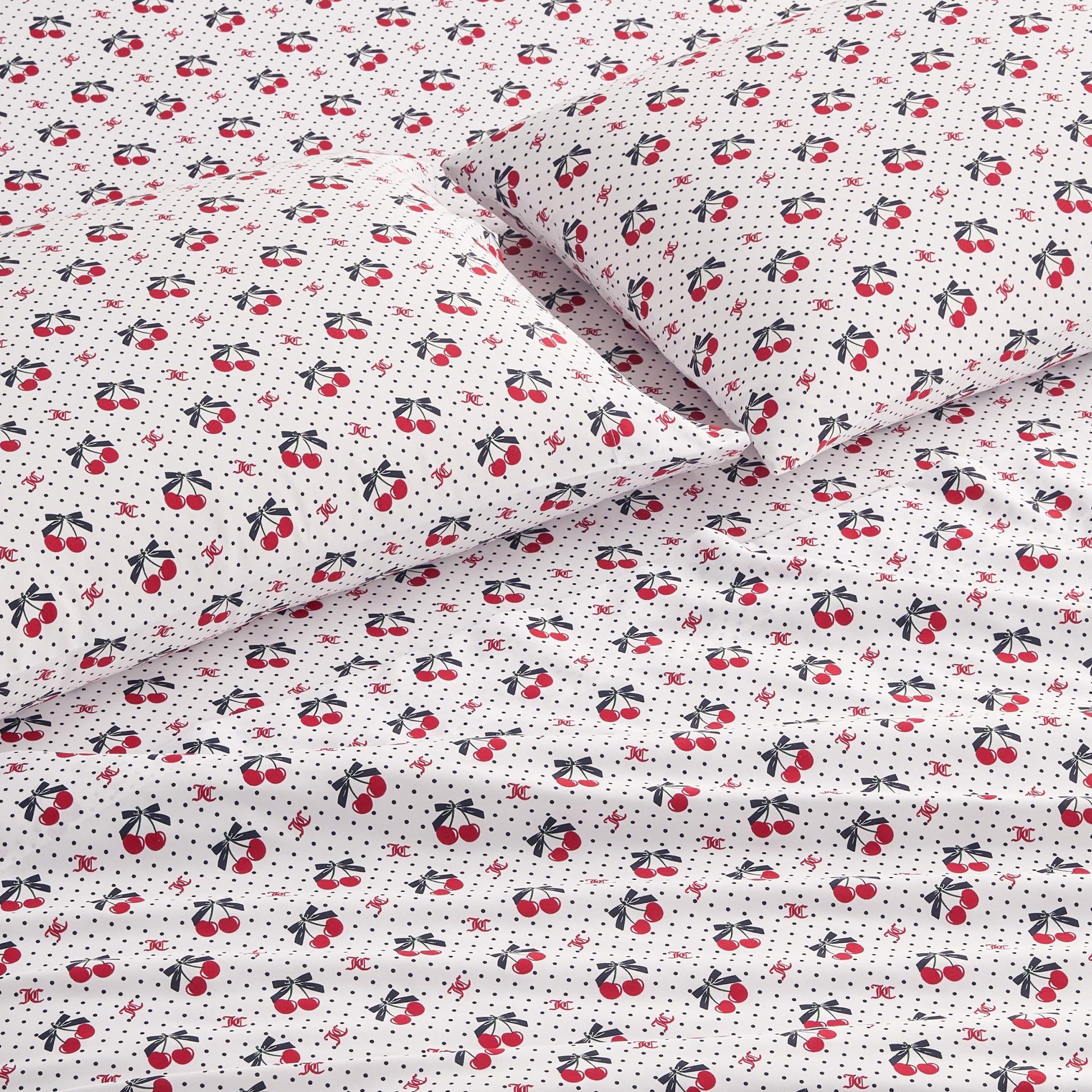 The Printed Microfiber Sheet Set features white sheets and pillowcases with a playful pattern of small red cherries, black leaves, and tiny black polka dots, adding cheerful style and luxurious comfort to your room.