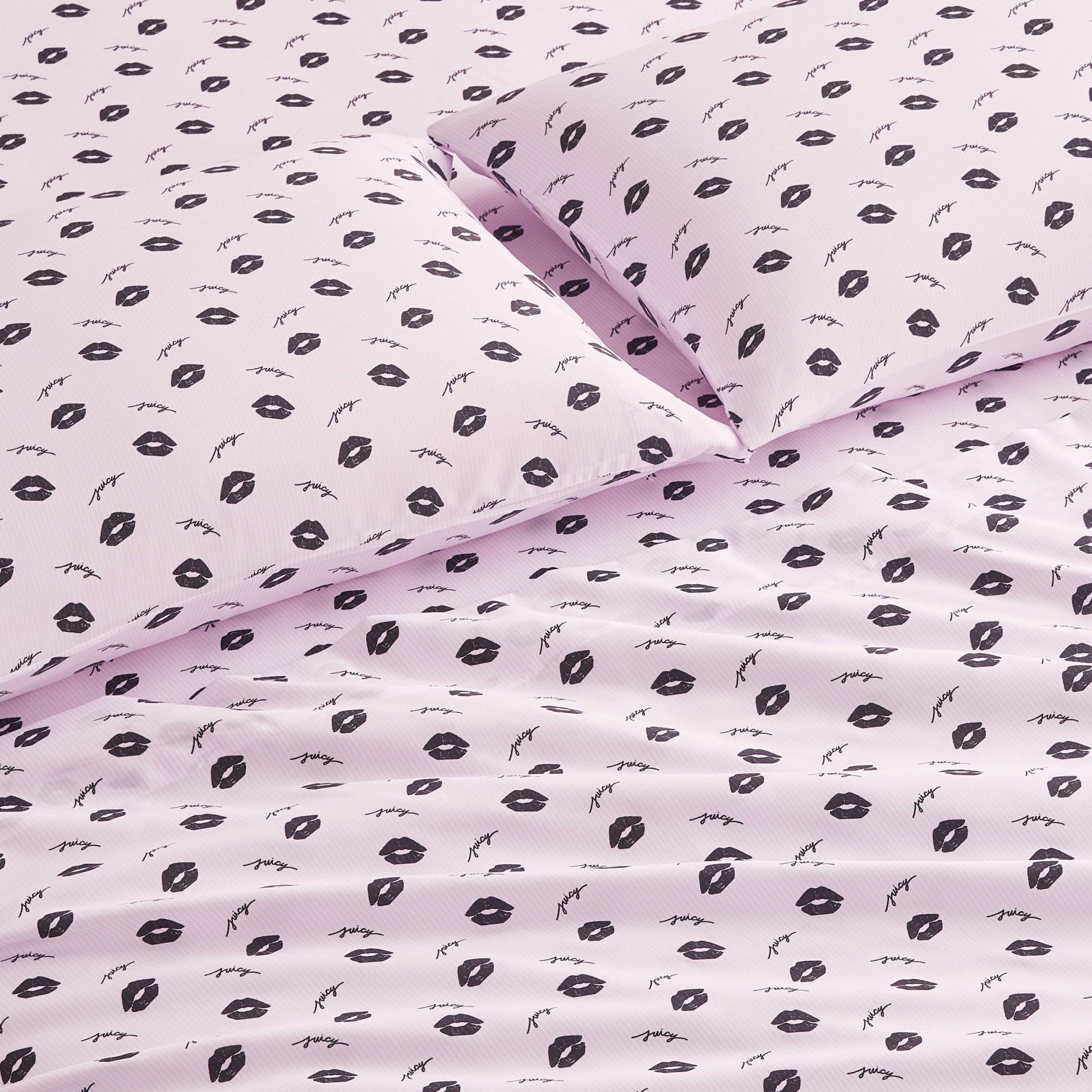 The Printed Microfiber Sheet Set in light pink features a chic pattern of black lips and eyelashes. Smooth and neatly arranged, this luxury bedding adds modern style to any room.