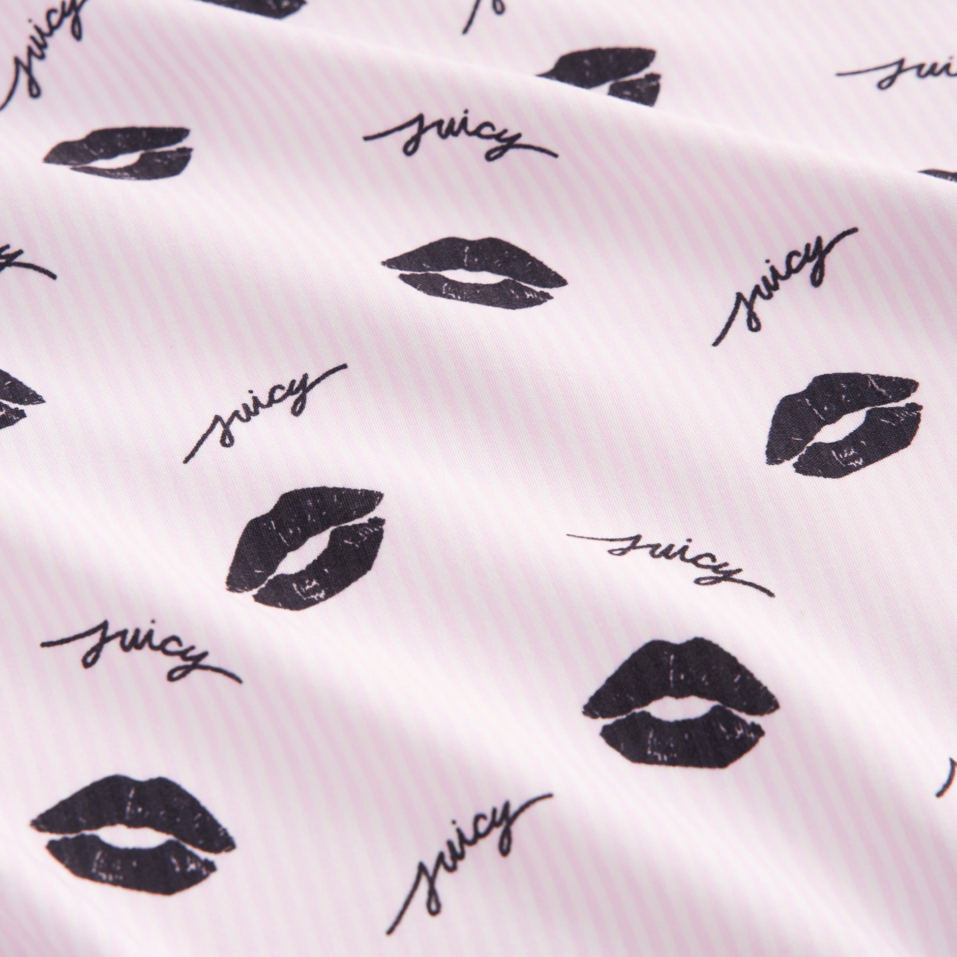The Printed Microfiber Sheet Set features white fabric with light pink stripes, black lip prints, and “juicy” in cursive—adding playful charm and style to your bedding collection.
