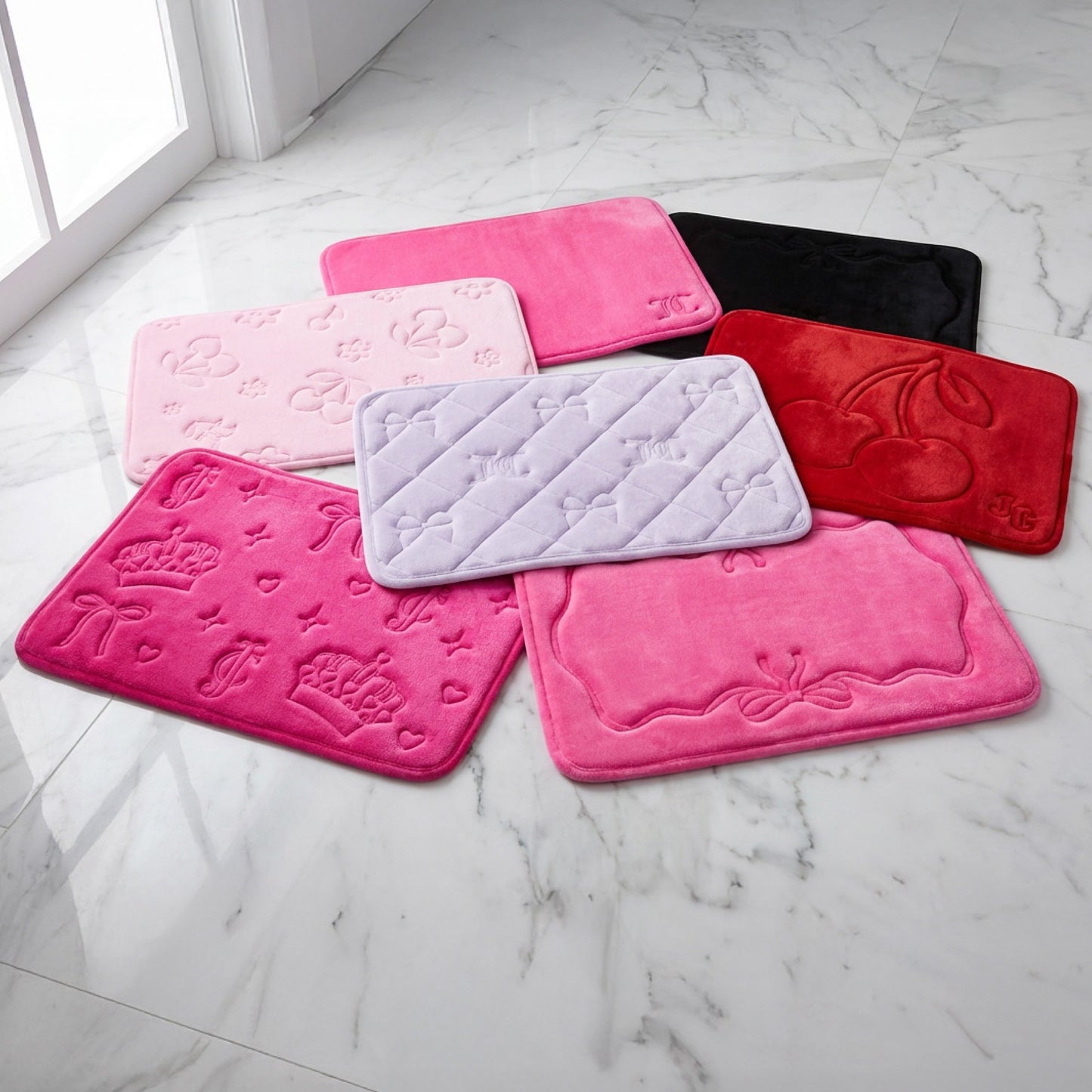 Seven rectangular, plush Quilted Memory Foam Bath Mats in pink, black, red, and lavender feature embossed patterns. Arranged on white marble by a window, these luxury rugs add vibrant style and comfort to your bathroom.