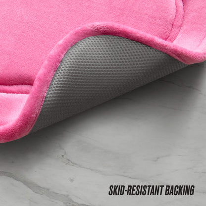 A close-up of the Quilted Memory Foam Bath Mat, 17" x 24", with one corner lifted to show its gray, textured skid-resistant backing. The mat is placed on a light gray marble floor. “SKID-RESISTANT BACKING” text appears in the corner.