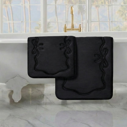 Two Quilted Memory Foam Bath Mats from the 2-piece set are placed on a marble floor near a white bathtub with gold fixtures, set by a large window overlooking scenic views.