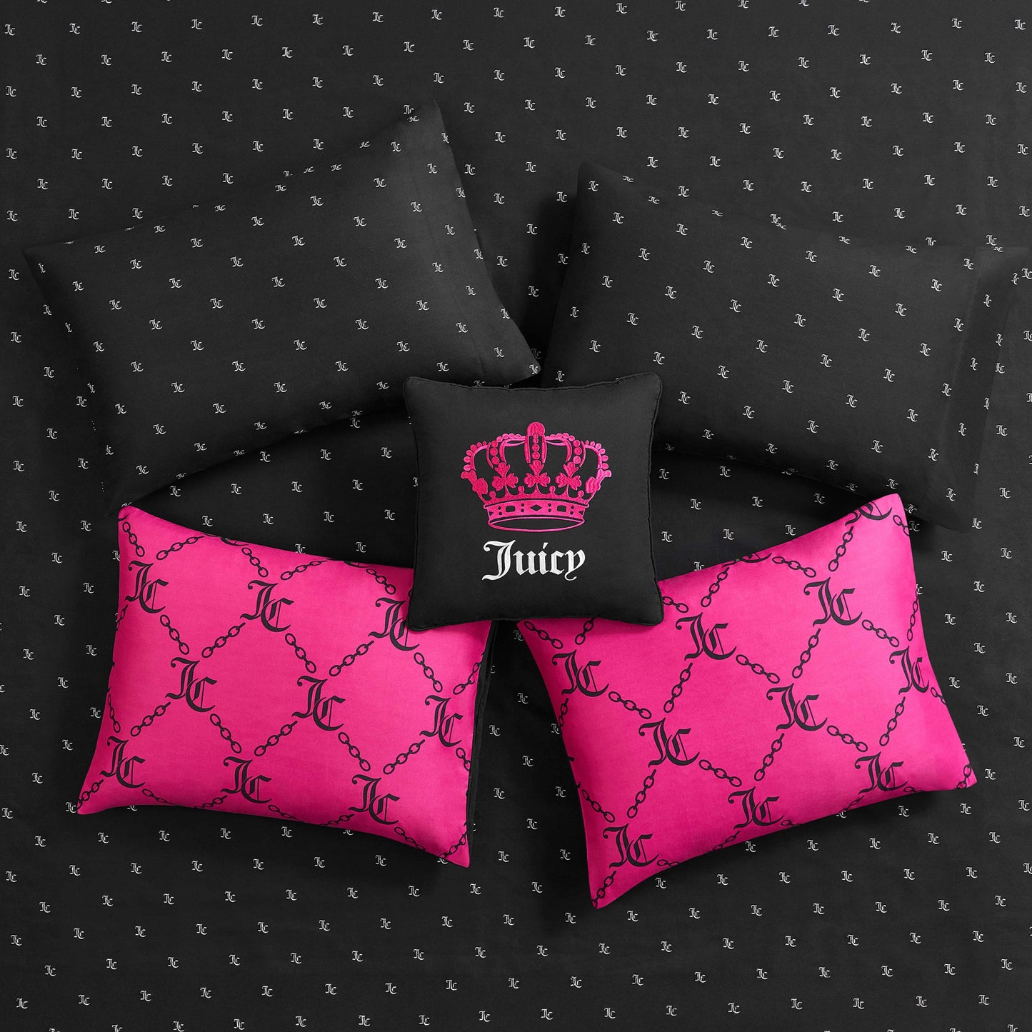 The Link Printed Bed in a Bag Bedding Set features four pillows: two with a bright pink chain and J pattern, one black with a pink crown and Juicy text, and one black with subtle repeating Js for a glamorous, luxurious look.