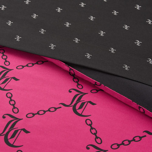 Folded fabric from the Link Printed Bed in a Bag Bedding Set displays two patterns: a black top layer with small white chain and monogram motifs, and a pink bottom layer featuring large black chains and monogram designs.