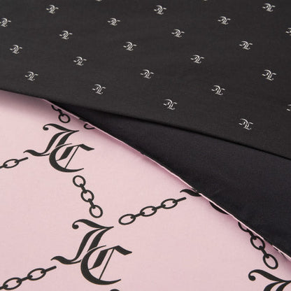 Close-up of two overlapping fabrics from the Link Printed Bed in a Bag Bedding Set: the top black layer shows a small white pattern, while the pink fabric below displays a bold black chain and interlocking JC monogram design.