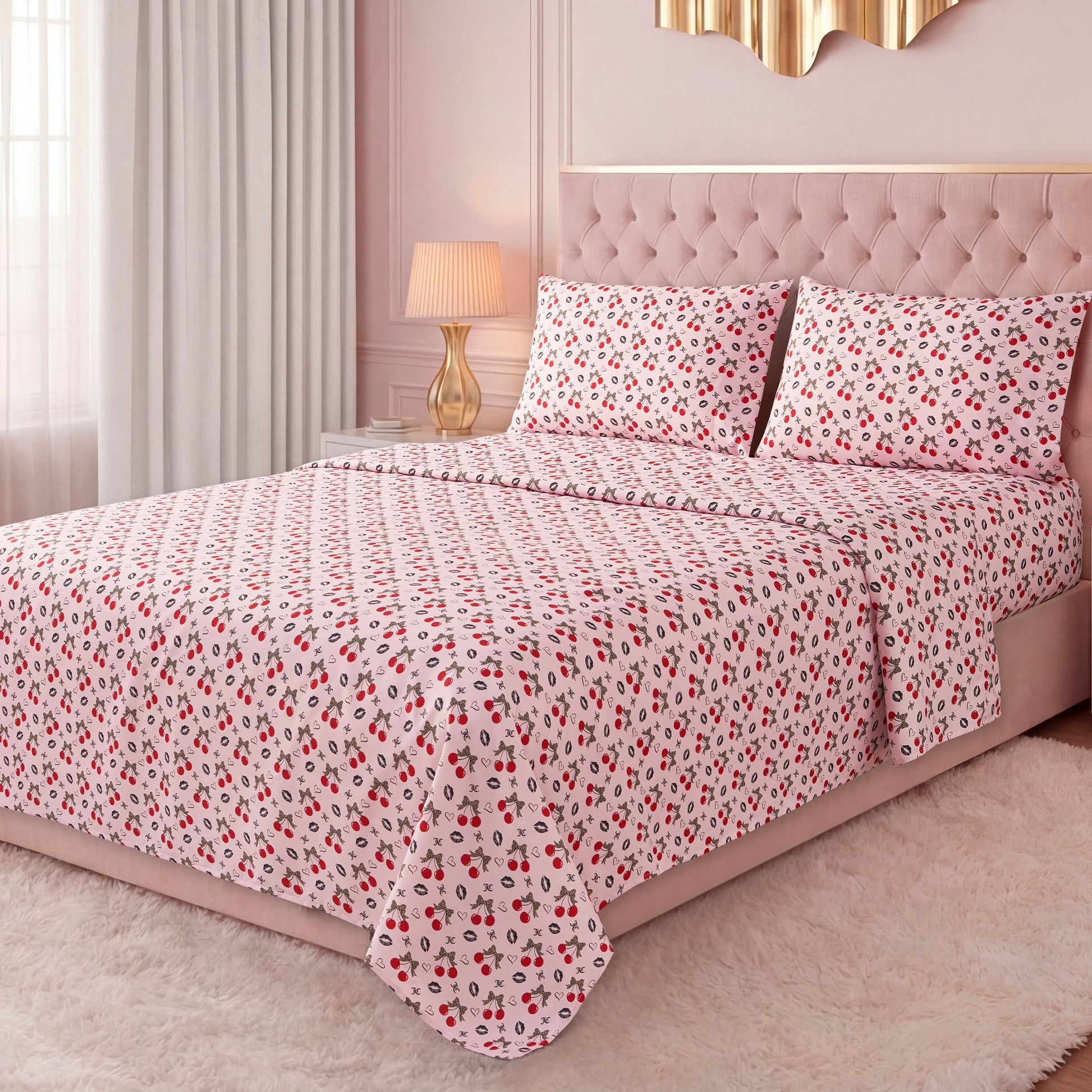 A bright bedroom features a neatly made bed with a pink tufted headboard, dressed in the Printed Microfiber Sheet Set with red and black floral patterns, complemented by pillows, curtains, a lamp, and a soft white rug.