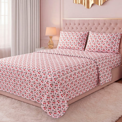 A bright bedroom features a neatly made bed with a pink tufted headboard, dressed in the Printed Microfiber Sheet Set with red and black floral patterns, complemented by pillows, curtains, a lamp, and a soft white rug.