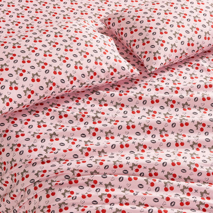 The Printed Microfiber Sheet Set features a cheerful pink design with red cherries, strawberries, lemons, and leaves. Its soft texture and playful fruit pattern create inviting, whimsical luxury bedding for your bedroom.
