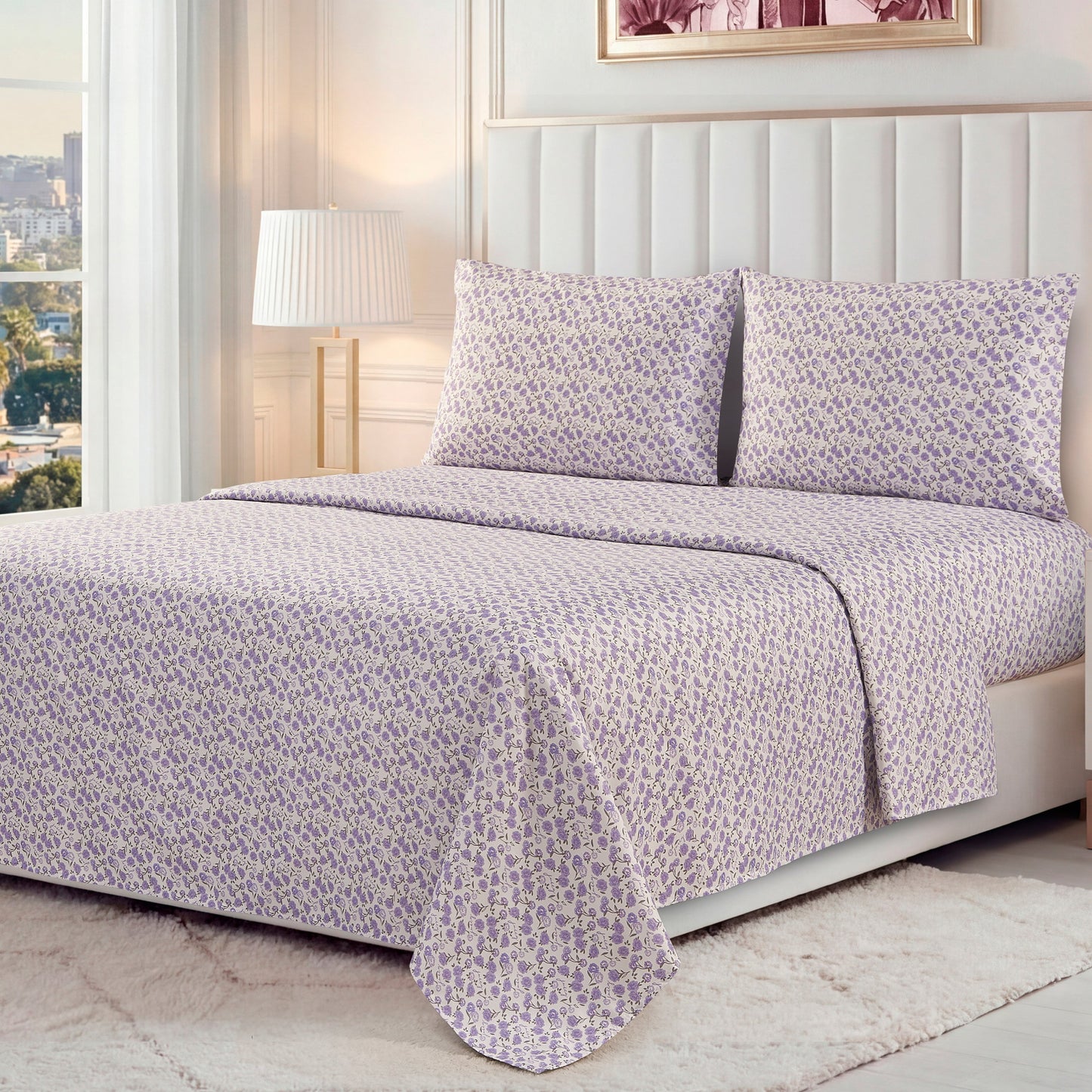 A neatly made bed features the Printed Microfiber Sheet Set in a light purple floral pattern, with matching pillowcases, in a bright modern bedroom with white walls, a large window, lamp, and white rug.