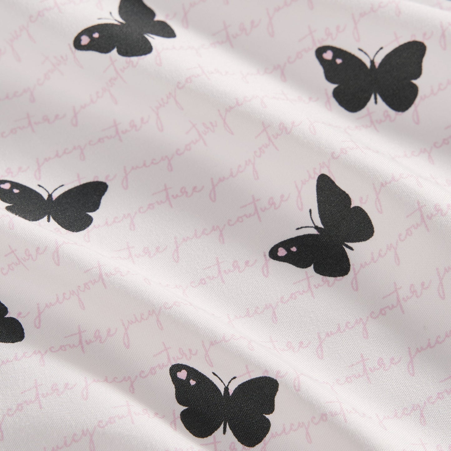 The Printed Microfiber Sheet Set features black butterfly designs and subtle pink Juicy Couture cursive text, bringing a touch of luxury to your bedding ensemble.