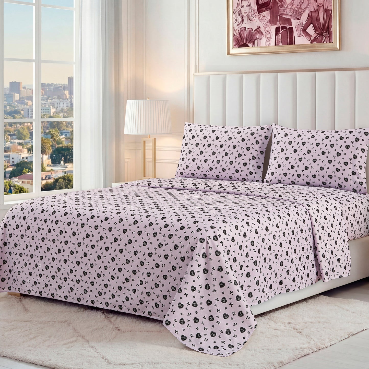 A neatly made bed with a Printed Microfiber Sheet Set in light pink and black floral pattern, two matching pillows, a padded white headboard, lamp, framed artwork, and a large window overlooking the city.