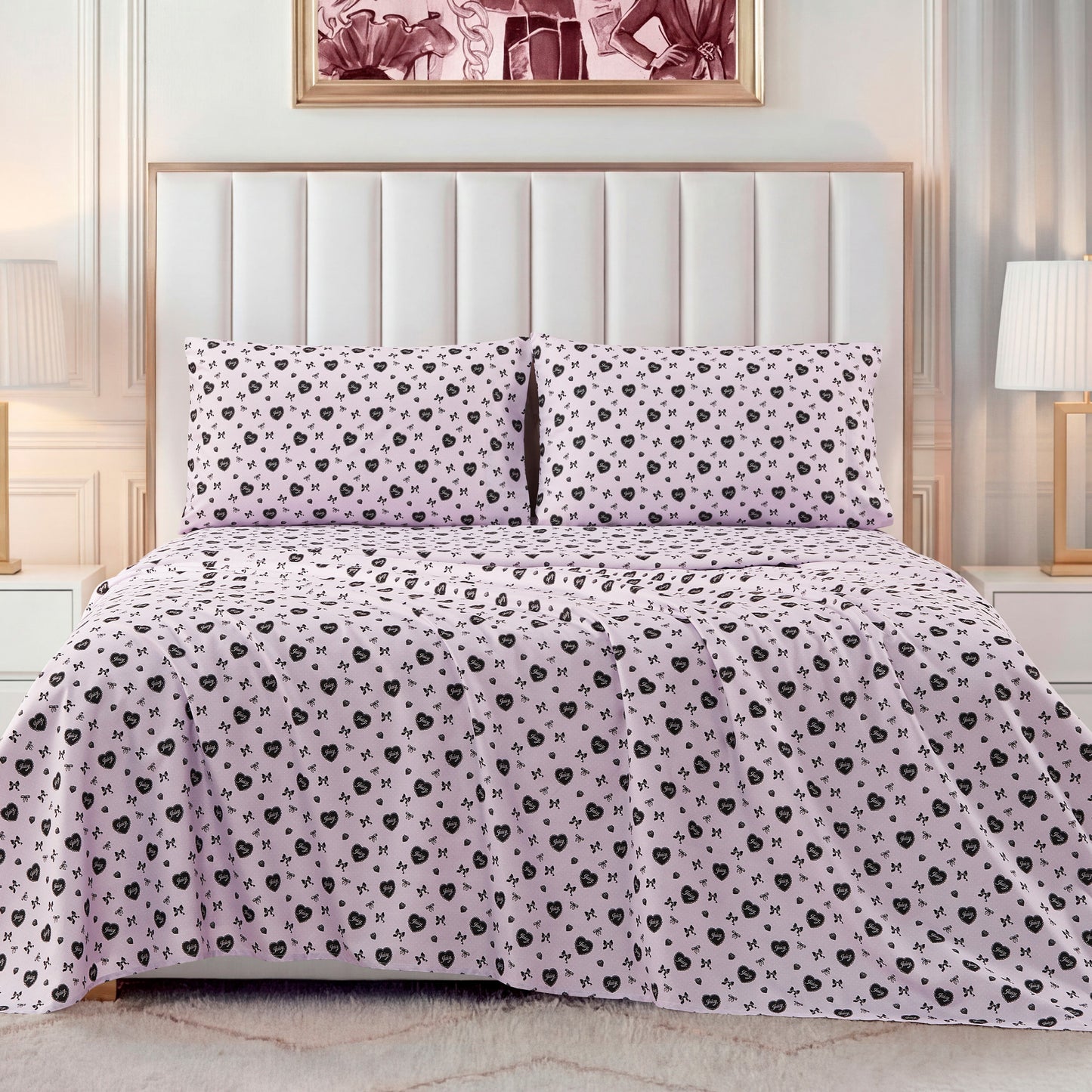 A neatly made bed with a light pink Printed Microfiber Sheet Set featuring a small black floral pattern, framed by a white headboard and flanked by two white lamps on bedside tables for a touch of luxury bedding.