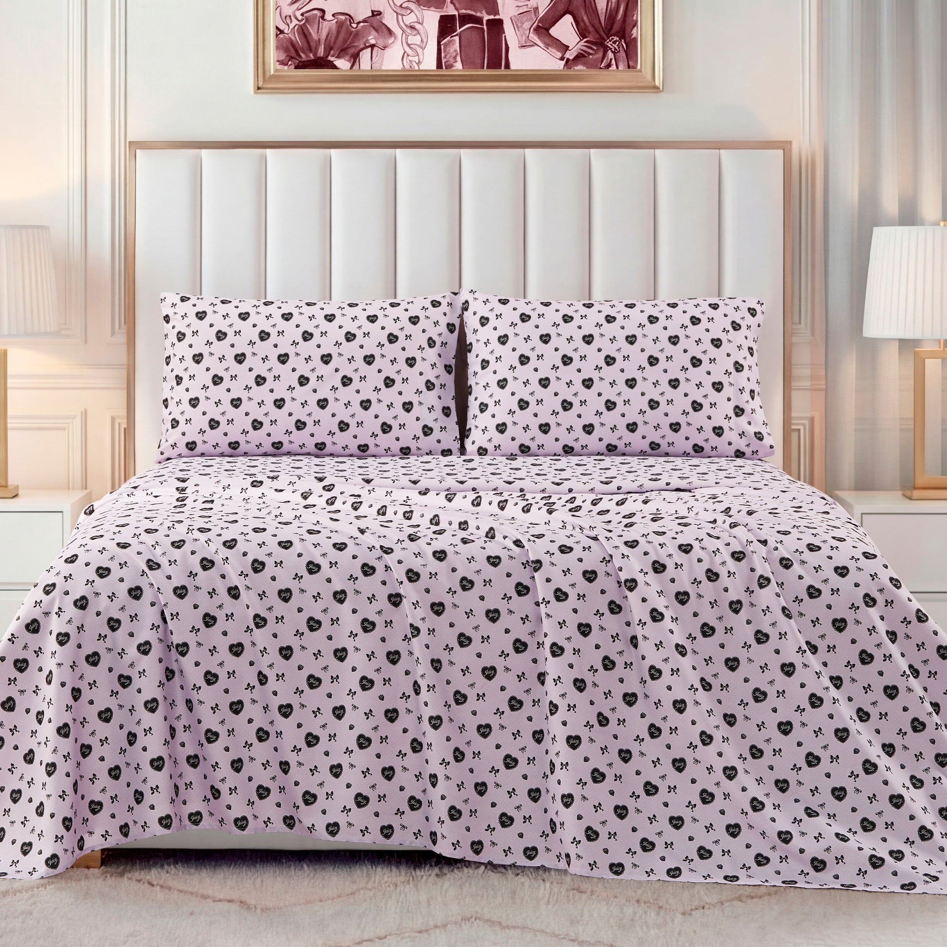 A neatly made bed with a light pink Printed Microfiber Sheet Set featuring a small black floral pattern, framed by a white headboard and flanked by two white lamps on bedside tables for a touch of luxury bedding.