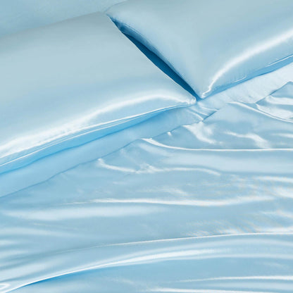 Close-up of the Solid Satin Sheet Set in light blue, featuring ultra-soft satin sheets and two matching pillowcases with a smooth, shiny surface and soft folds for a luxurious look.