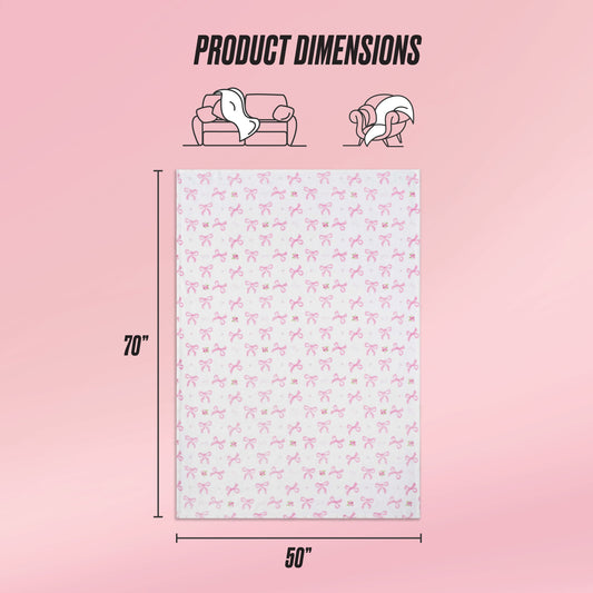 The Kids Plush Throw Blanket is a rectangular Juicy Couture blanket measuring 70" x 50", featuring a pink bow pattern and ultra-soft, pink background—perfect as a plush couch throw or cozy wrap. Product Dimensions shown above.