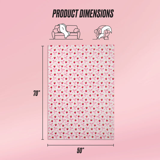 A Kids Plush Throw Blanket by Juicy Couture features a pink cherry pattern and measures 70x50 inches. Icons indicate sofa and wearable uses, while a soft pink gradient background highlights the ultra-soft plush texture. Text: Product Dimensions.