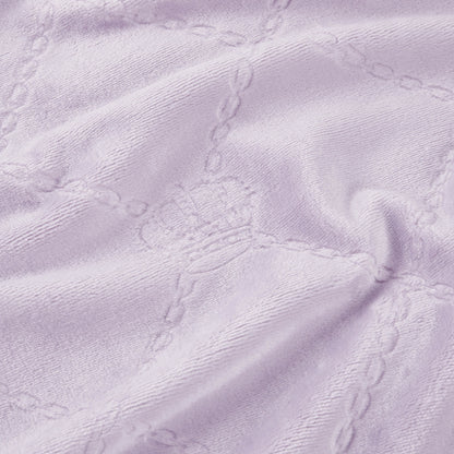 Light purple textured fabric with embossed crowns and chain-like grid lines creates a soft, cozy Plush Oversized Throw Blanket, 60" x 90". Perfect for adding Juicy Couture-inspired elegance to any twin bed.