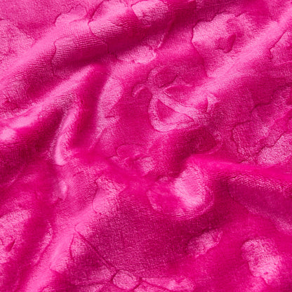 Close-up of the Plush Oversized Throw Blanket, 60" x 90", in bright pink with a subtle floral pattern. The ultra-soft, shiny textured fabric is gently wrinkled, highlighting captivating light and shadow variations.