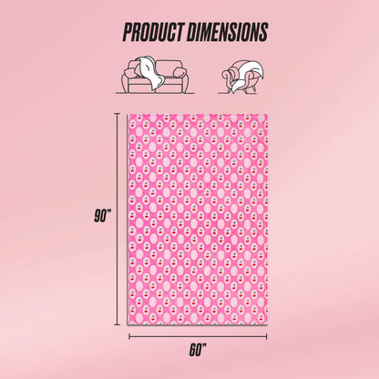 The Plush Oversized Throw Blanket is displayed upright, showing its pink color with a repeating white and red pattern. Measuring 90 x 60 inches, this ultra-soft blanket appears next to couch and person icons for scale under Product Dimensions.