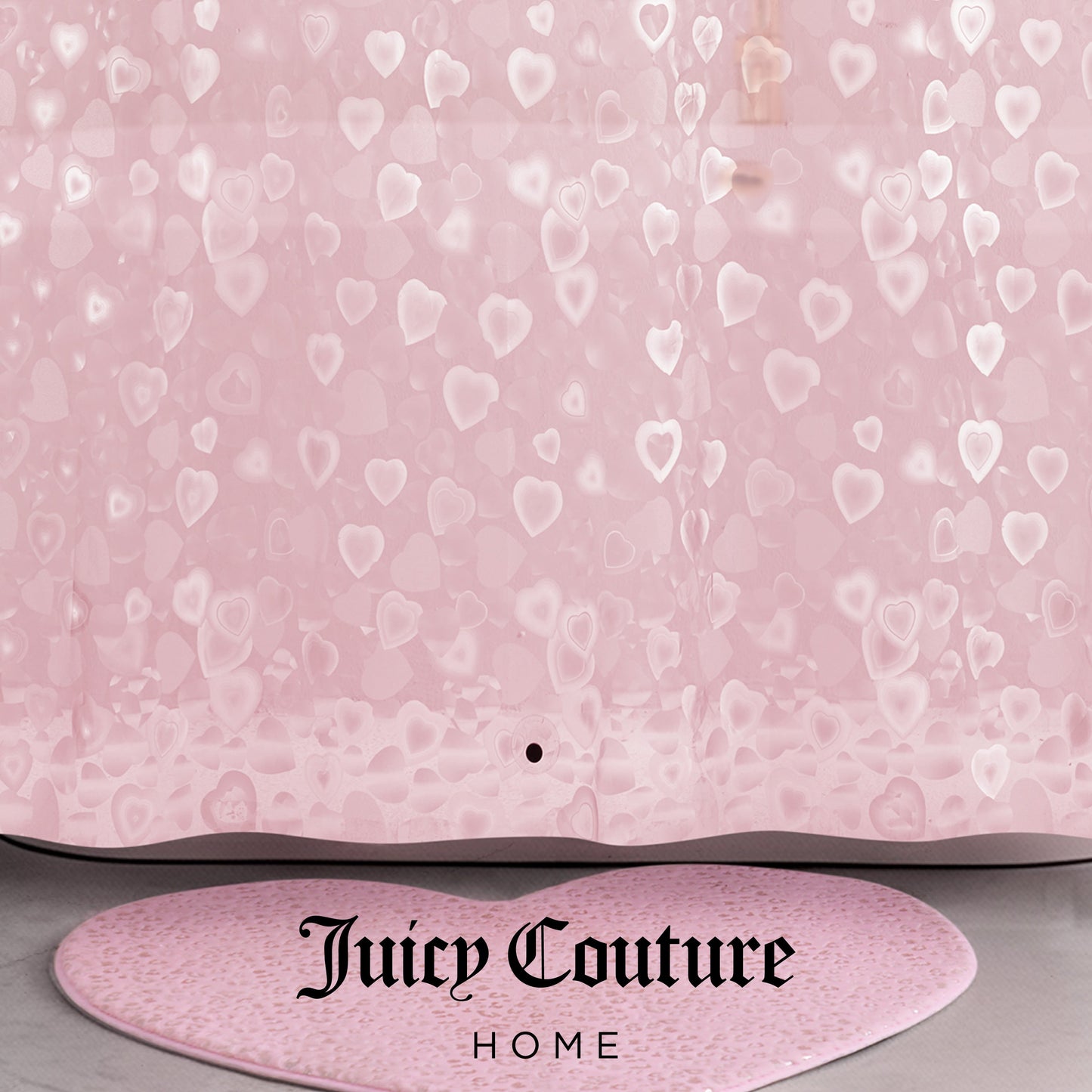 A pink PEVA Shower Curtain Liner with translucent heart patterns and "Juicy Couture Home" printed in black at the bottom, paired with a matching pink heart-shaped bath rug.