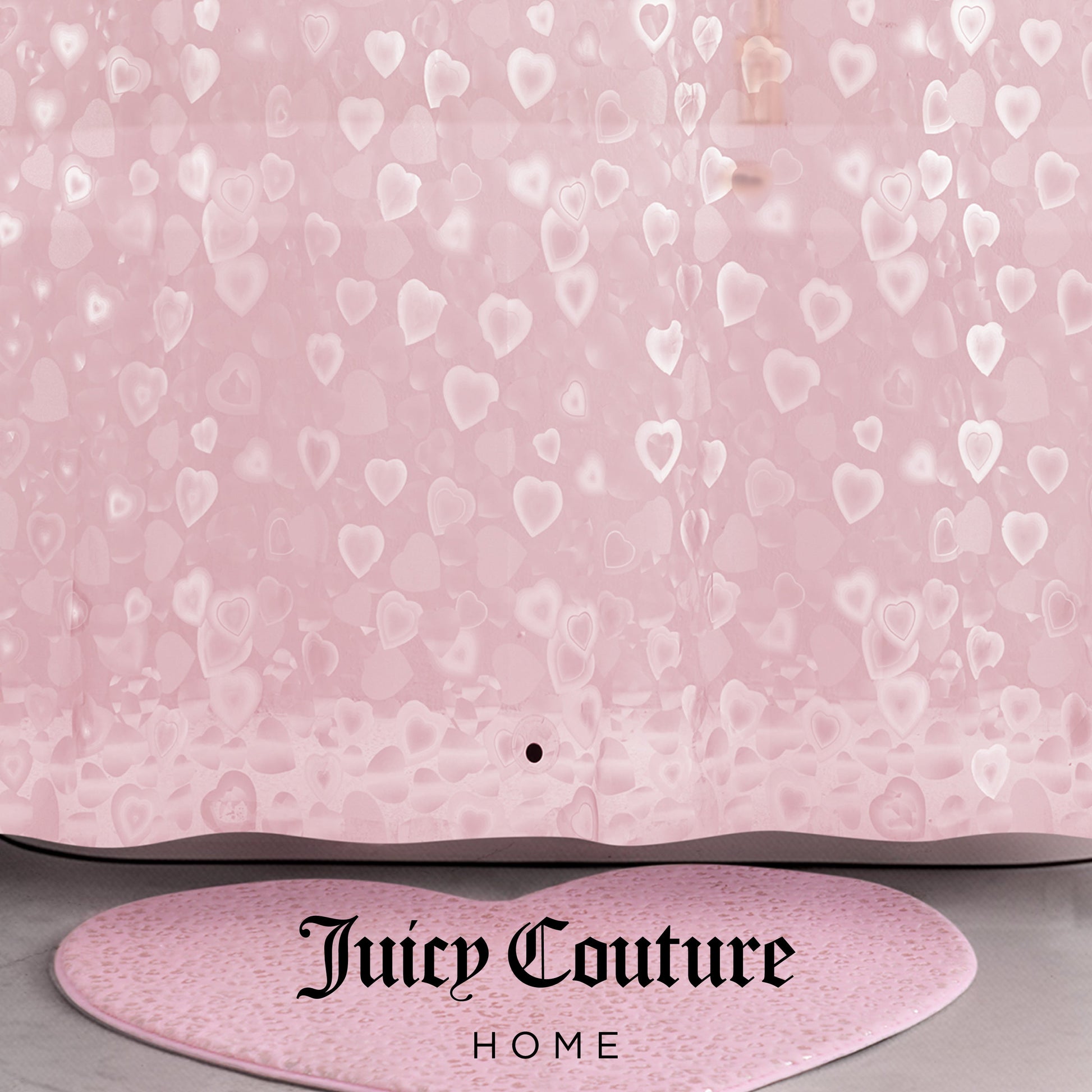 A pink PEVA Shower Curtain Liner with translucent heart patterns and "Juicy Couture Home" printed in black at the bottom, paired with a matching pink heart-shaped bath rug.