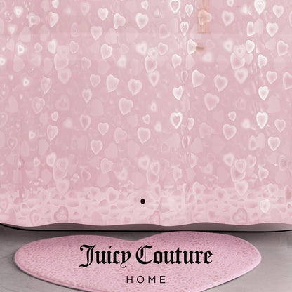 A pink PEVA Shower Curtain Liner with translucent heart patterns and "Juicy Couture Home" printed in black at the bottom, paired with a matching pink heart-shaped bath rug.