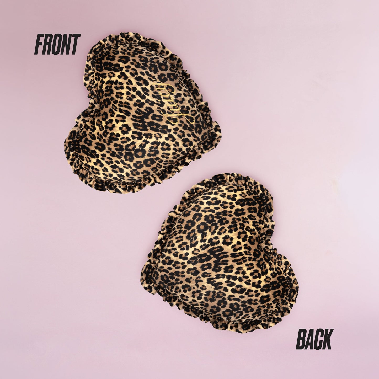 The Heart Shaped Decorative Pillow features a chic Juicy Couture-inspired cheetah print, shown front and back on a light pink background, with both sides displaying the same stylish pattern.