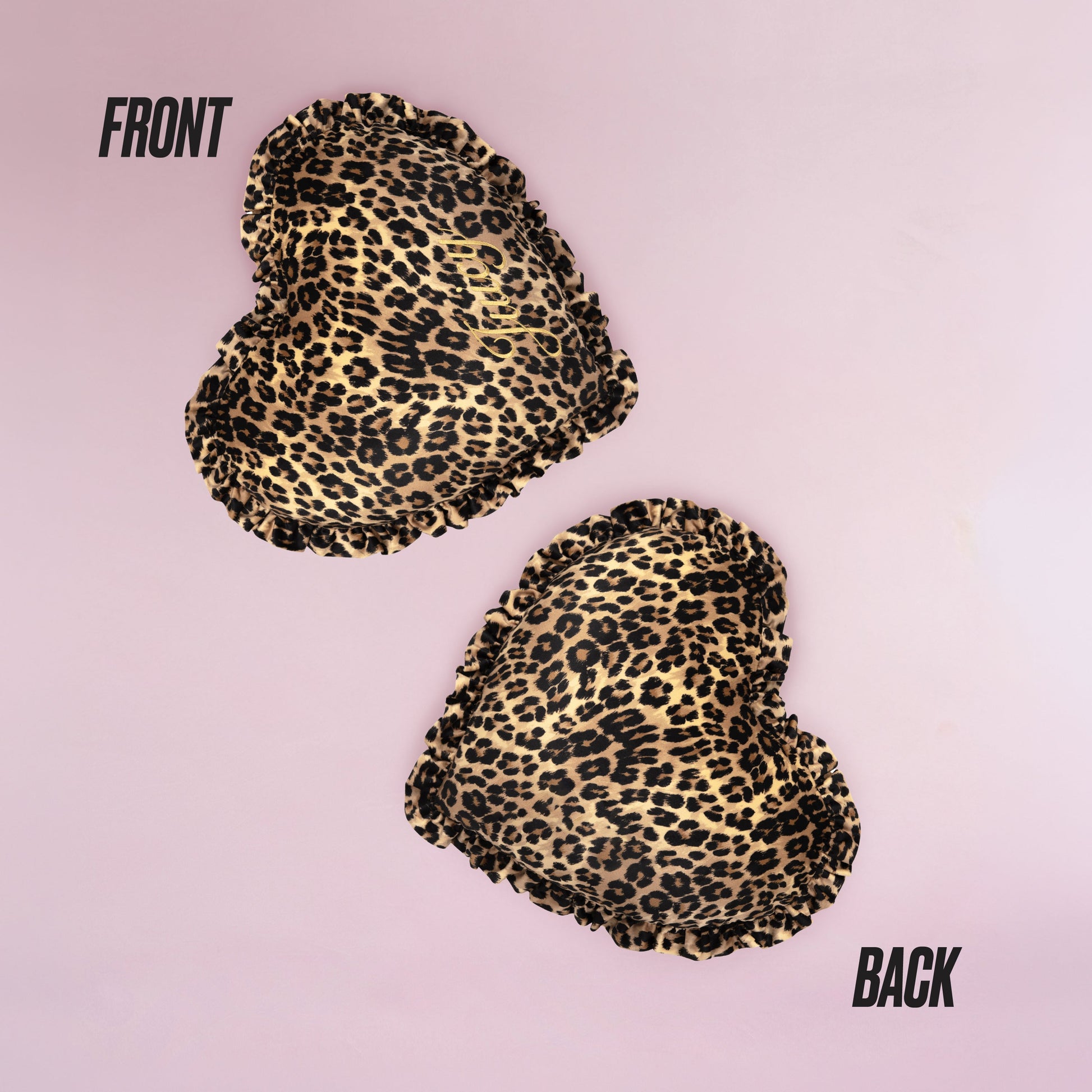 The Heart Shaped Decorative Pillow features a chic Juicy Couture-inspired cheetah print, shown front and back on a light pink background, with both sides displaying the same stylish pattern.