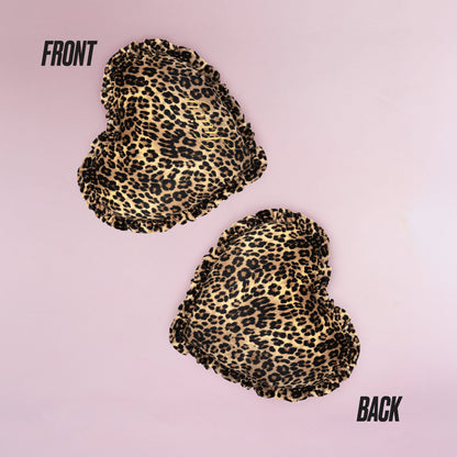 The Heart Shaped Decorative Pillow features a chic Juicy Couture-inspired cheetah print, shown front and back on a light pink background, with both sides displaying the same stylish pattern.