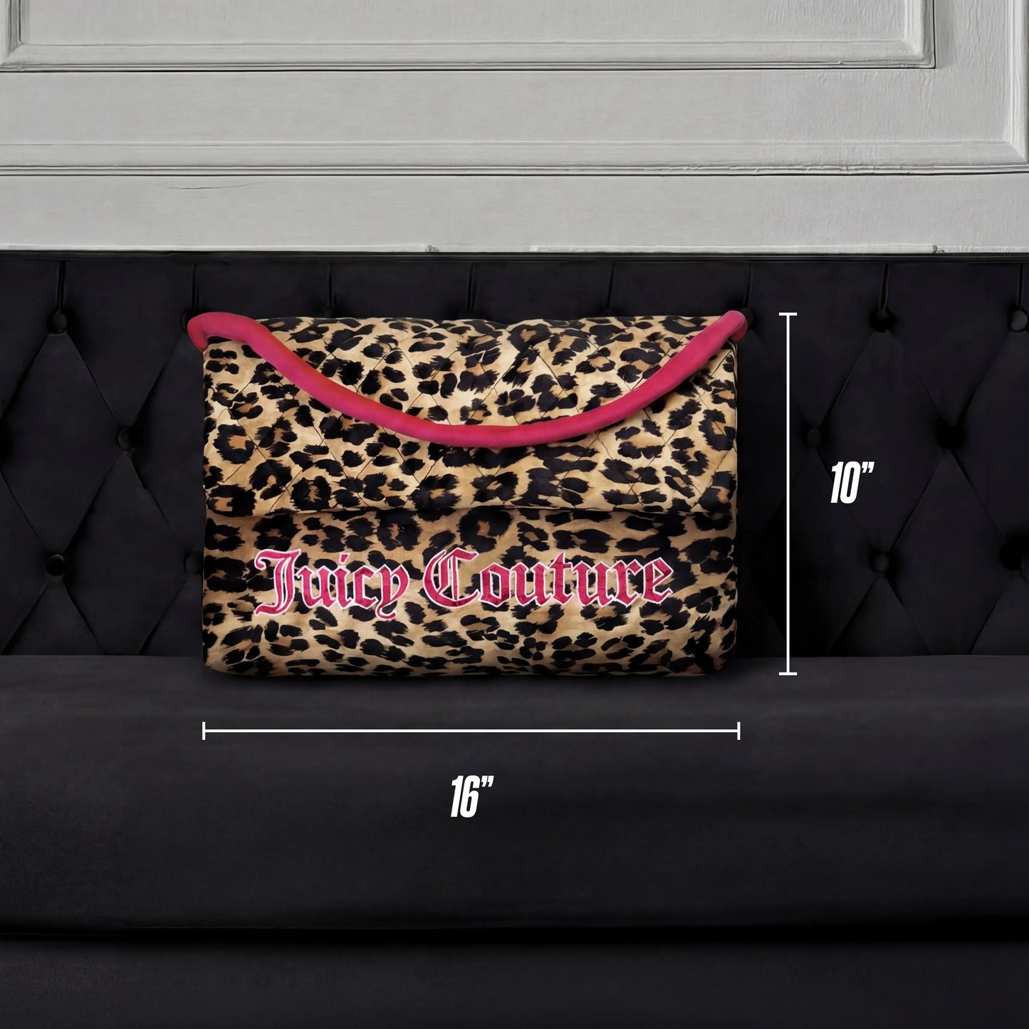 The Purse Decorative Pillow, featuring a leopard print with pink trim and logo, measures 16" x 10" and is shown on a black tufted sofa against a white panel backdrop—a chic accent for any room.
