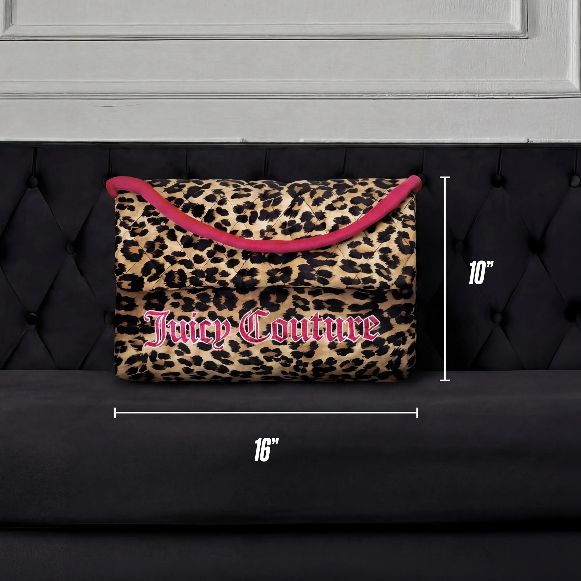 The Purse Decorative Pillow, featuring a leopard print with pink trim and logo, measures 16" x 10" and is shown on a black tufted sofa against a white panel backdrop—a chic accent for any room.