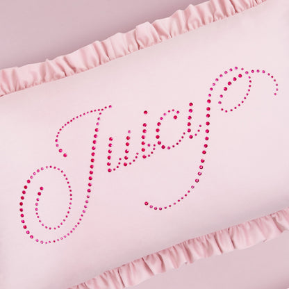 The Ruffle Decorative Pillow is light pink with ruffled edges and features "Juicy" in pink rhinestone cursive across the front.