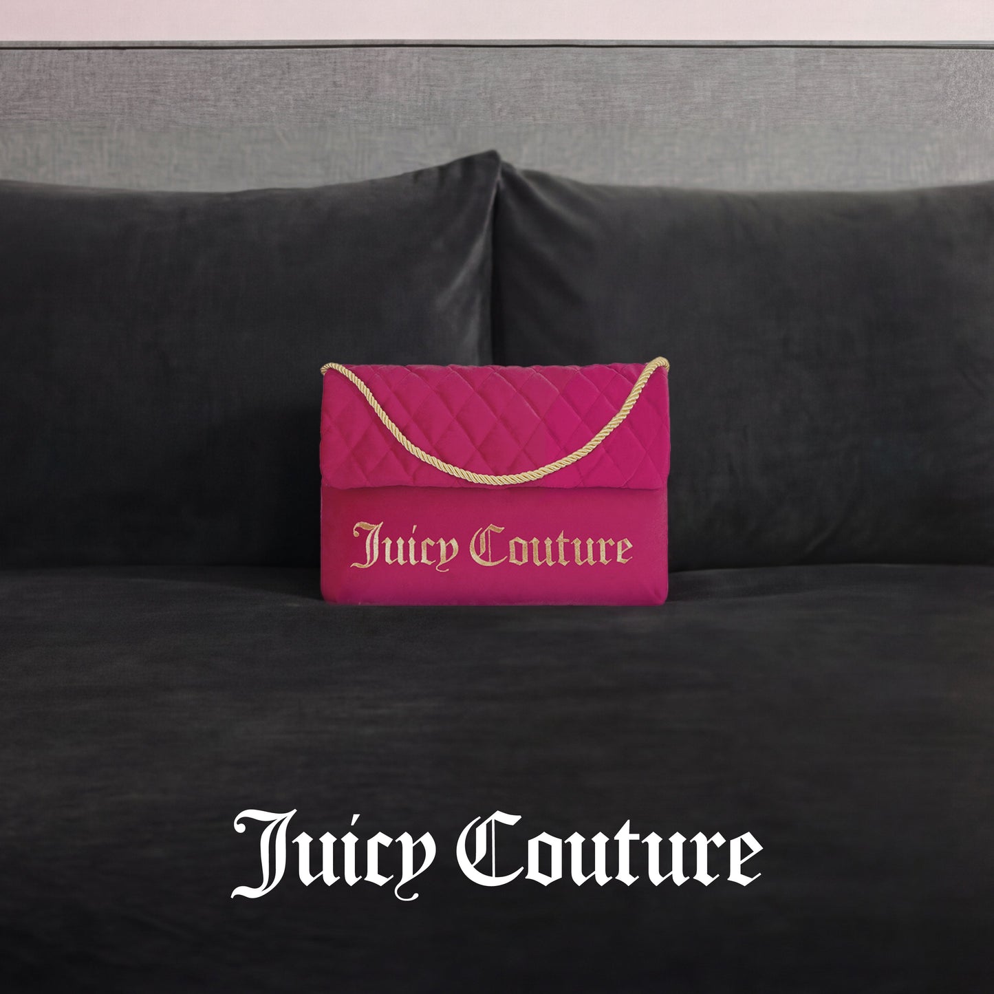 The Purse Decorative Pillow, styled like a pink quilted Juicy Couture handbag with a gold chain and logo, adds a trendy accent to any dark gray velvet couch. "Juicy Couture" is displayed in white text below.