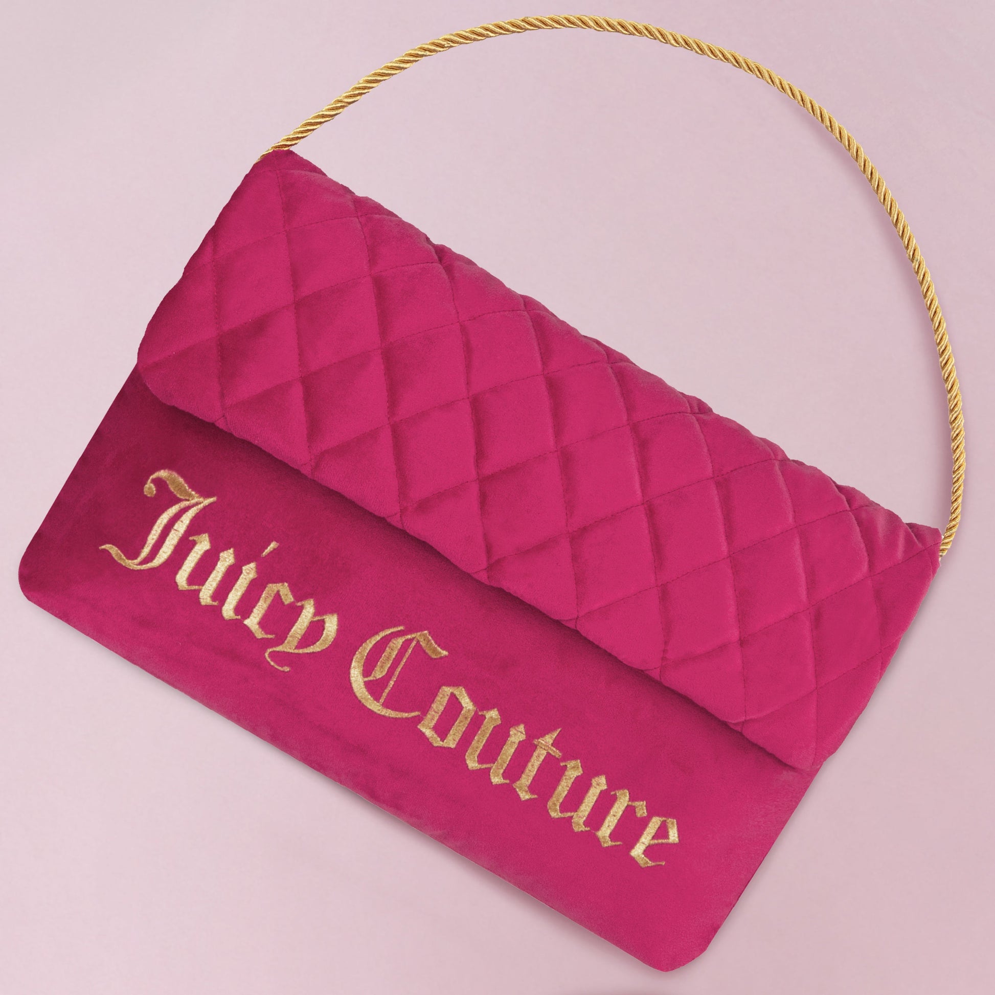 The Purse Decorative Pillow features a pink quilted design with a gold rope handle and bold “Juicy Couture” lettering on the front—perfect as a chic accent or stylish decor for any space.