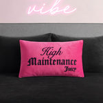 A bright pink Reversible Decorative Pillow with "High Maintenance Juicy" in black gothic font rests on a dark gray couch, with a glowing neon pink vibe sign on a light pink wall. This stylish accent adds playful energy to any space.